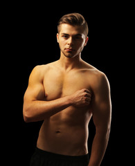 Fototapeta premium Muscle young man on dark background