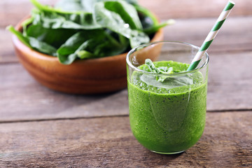 Glass of spinach juice on wooden background