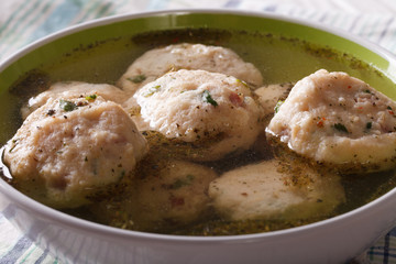 canederli in a broth close up in a bowl. horizontal 
