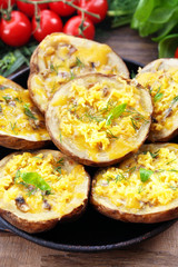 Baked potatoes with cheese and mushrooms on table close up
