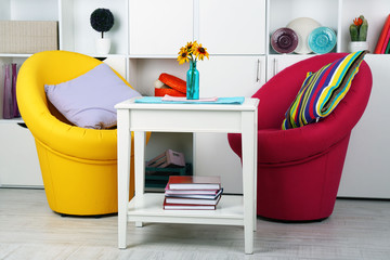 White living room with armchairs and bookcase