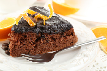Cake with Chocolate Glaze and orange on plate, on wooden background