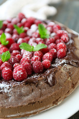 Cake with Chocolate Glaze and raspberries on wooden background
