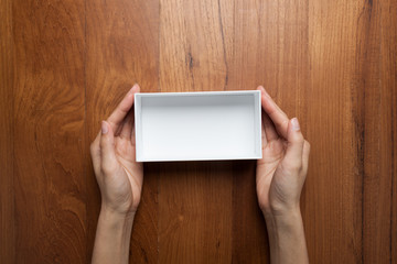 A female(woman, girl) two hands hold the empty(blank) white box,