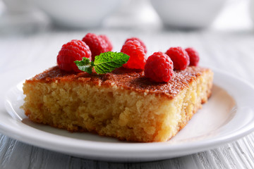 Fresh pie with raspberry in white plate on wooden table, closeup