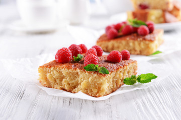 Fresh pie with raspberry on parchment on wooden table, closeup