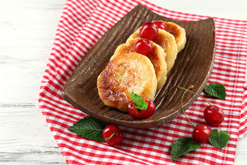 Fritters of cottage cheese with berries in plate, closeup