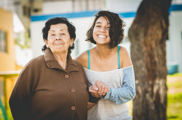 Lovely grandmother and granddaughter standing together posing