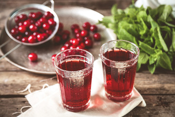 Two glasses with cherry juice on table, on wooden background