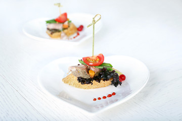 Tasty canapes on wooden table, close up