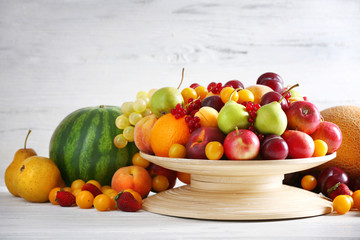Heap of fresh fruits and berries on wooden background
