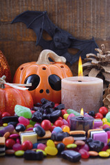 Halloween Candy with pumpkins on dark wood background.
