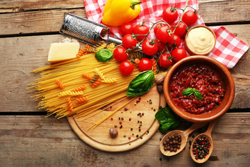 Pasta spaghetti with tomatoes, sauce bolognese, cheese and basil on rustic wooden  background