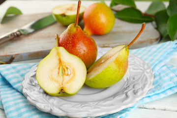 Fresh pears on wooden table with napkin, closeup