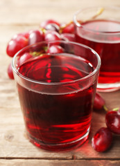 Glass of grape juice on wooden table, closeup