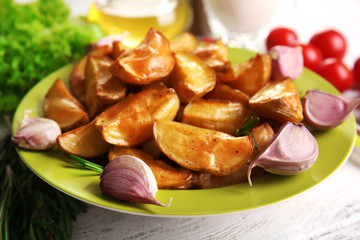 Baked potato wedges on wooden table, closeup