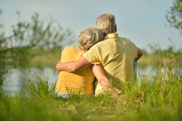 Fototapeta premium Senior couple sitting near lake