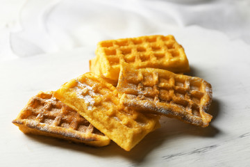 Sweet homemade waffles on tray, on light background
