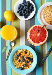 Tasty cornflakes with fruits and berries on table close up