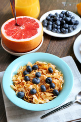 Tasty cornflakes with fruits and berries on table close up