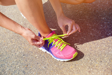 Frau schn&uuml;rt ihre Sportschuhe