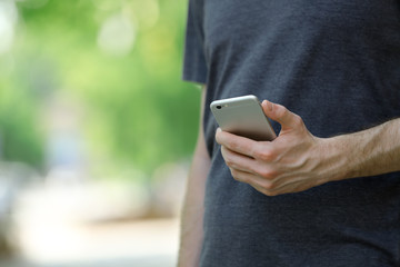 Man holding smart mobile phone outdoors