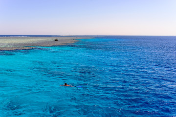 Man swimming in the ocean off a sand bank