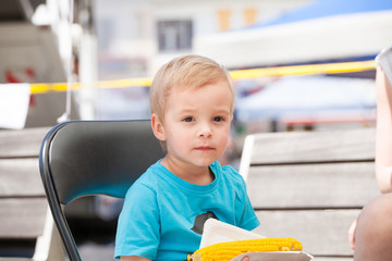 A little boy and corn on the cob. © rades