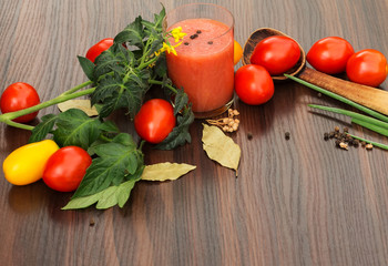 glass of tomato juice with tomatoes on the table