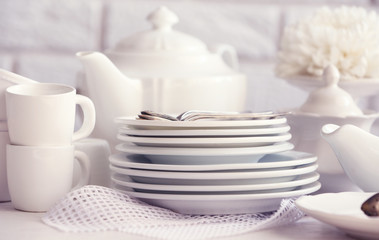 Clean dishes on table on brick wall background