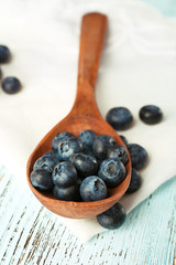 Fresh blueberries in spoon on wooden table close up