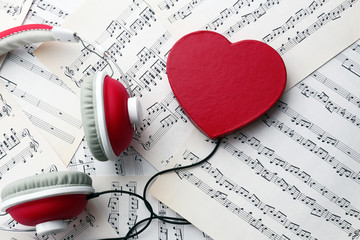 Earphones with red heart on music notes background