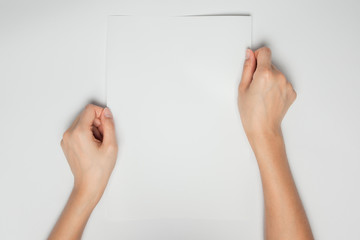 A female(woman) hands hold a empty(blank) white paper isolated w