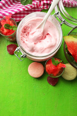 Watermelon ice cream in glass jars  on color wooden background