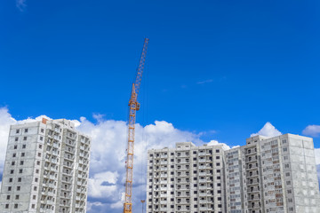 Fototapeta na wymiar Construction of high-rise houses and building crane