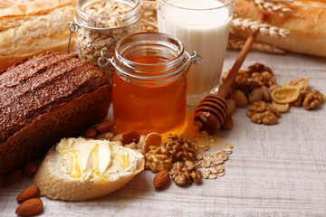 Fototapeta na wymiar Healthy breakfast with bread, honey, nuts on table, on colorful background. Country breakfast concept