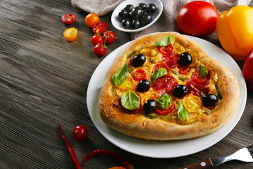 Heart shaped pizza served on plate on wooden background