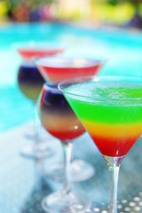 Cocktails on swimming pool background
