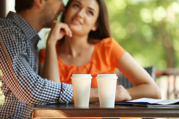 Young couple drink coffee in cafe outdoors