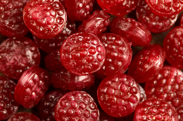 Pile of tasty delicious raspberry hard candy lying on wooden