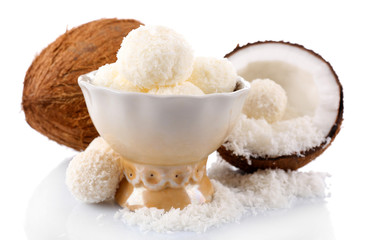 Candies in coconut flakes and fresh coconut isolated on white