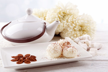 Homemade coco sweets on plate, on light background