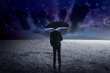 Man holding umbrella from outer space