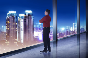 Fototapeta premium Business man looking the city from his office room