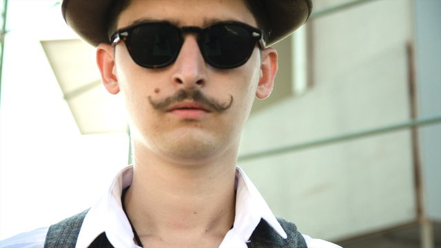 The gentleman in a hat, sunglasses and a mustache. thirties.