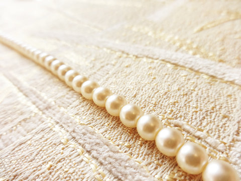 strand of pearls on beautiful fabrics