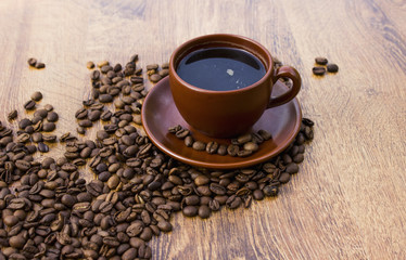 Cup of coffee on a wooden background with coffee beans