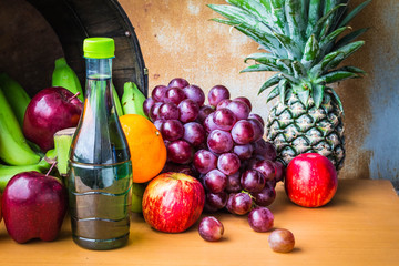 Bottles of juice and fruits on a table.