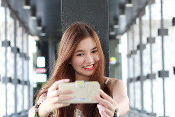 Portrait of thai adult beautiful girl using her smart phone Selfie.