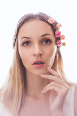 Fototapeta premium Portrait of beautiful young woman with flowers in hair. Soft focus on eyes.
